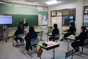 忠類中学校出前講座で町長がモニターに映された内容を説明している様子