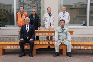 寄贈された木製ベンチでの集合写真