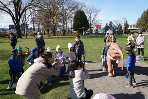 子どもたちが象の模型に乗って写真を撮っている様子