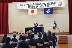 記念式典であいさつを述べている様子