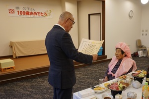 棚 久子さんに100歳のお祝いと記念品をお渡ししている様子