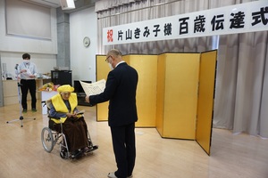 片山きみ子さんに100歳のお祝いと記念品をお渡ししている様子