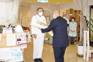 忠類診療所の塩塚 実医師へ花束を贈呈している様子