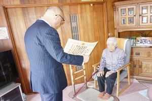 竹ケ原梅子さんに100歳のお祝いと記念品をお渡ししている様子