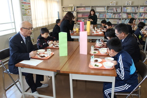 忠類小学校の4年生とハンバーグを試食する様子